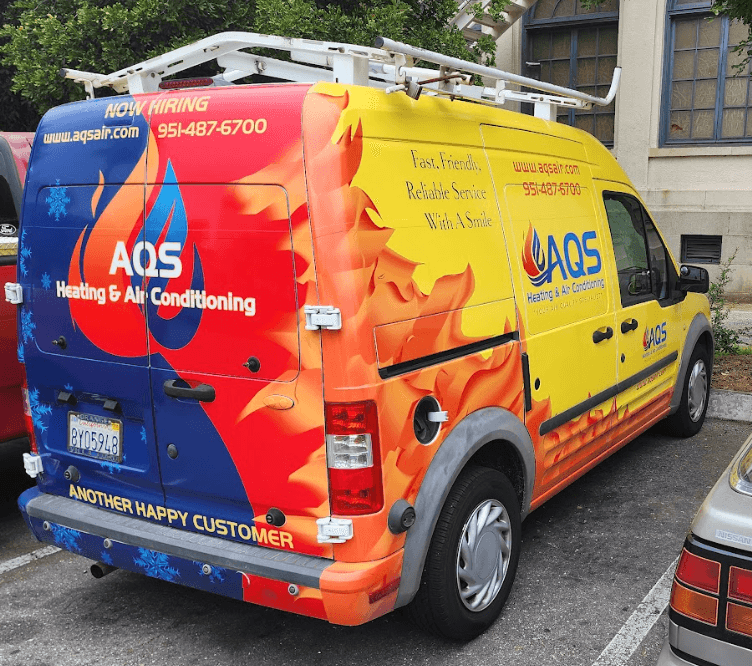 AQS Heating & Air Conditioning service van featuring vibrant branding with flames and snowflakes, showcasing contact information and hiring notice, parked in a lot.